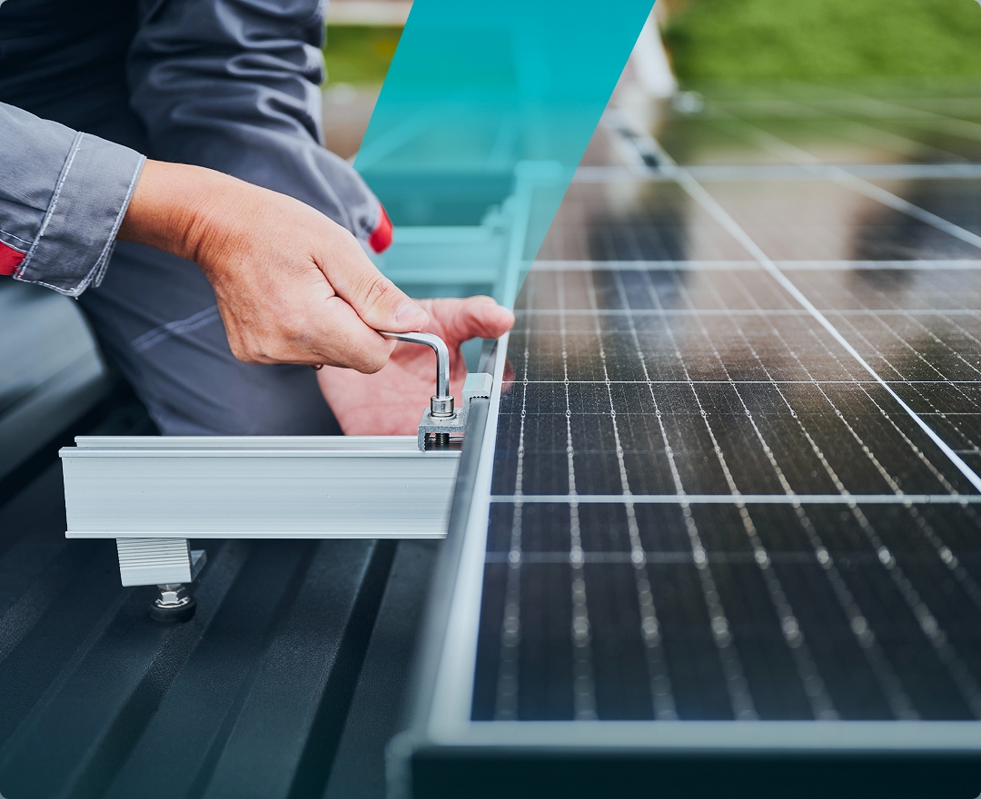 The image shows a solavita worker installing a solar panel. The worker is using a tool to secure the frame of the solar panel onto the roof, highlighting the installation process of the solavita solar pv system
